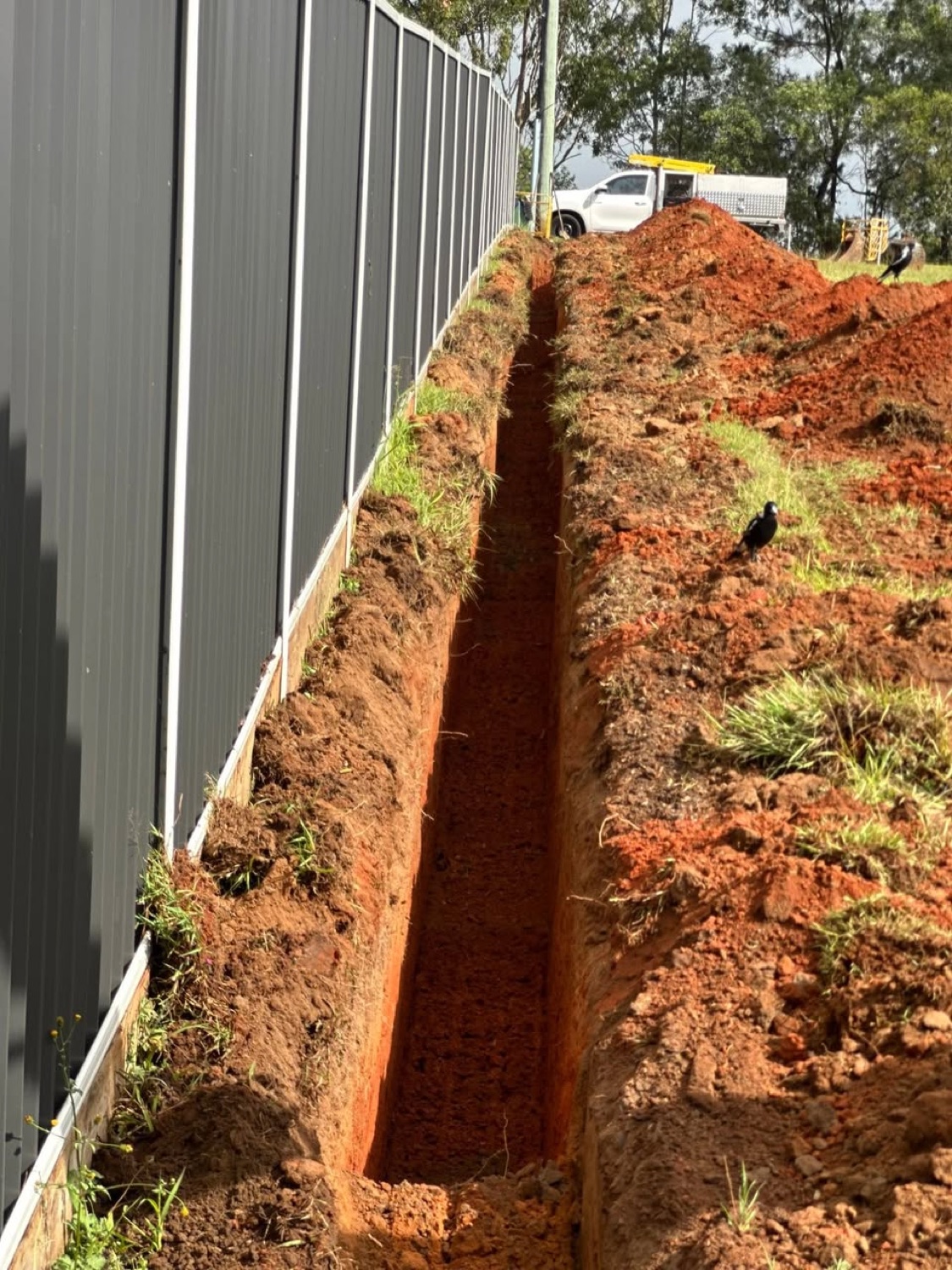 Finished service trench beside a fence